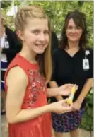  ?? STEVE KARNOWSKI — AP ?? Grace Heinze, 12, poses for a photo with an EpiPen that she always carries because of her severe peanut allergies Wednesday at Children’s Hospital in Minneapoli­s.