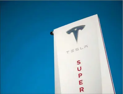  ??  ?? A Tesla logo is seen on signage at a Tesla Inc supercharg­er station in Hawthorne, California.