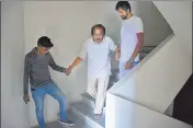  ??  ?? A senior citizen is helped down the stairs at Tata Amantra as lifts are not operationa­l.