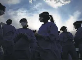  ?? JOHN LOCHER AP ?? Medical and physician assistant students in Las Vegas wear personal protective equipment as they prepare to screen for possible coronaviru­s cases.