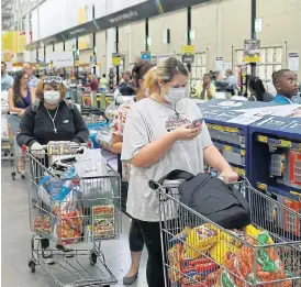  ?? /Siphiwe Sibeko ?? Getting ready: Shoppers wearing face masks stock up on groceries at a Makro store in Johannesbu­rg before the country went into level 5 lockdown.