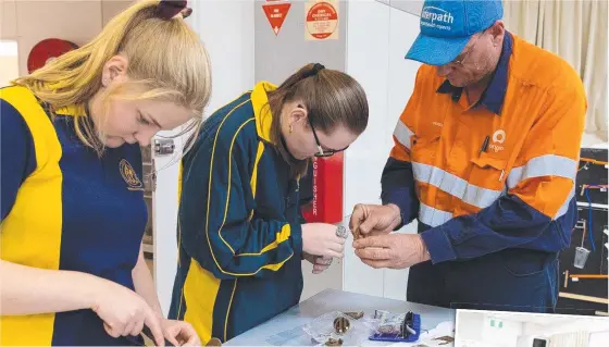  ?? Pictures: Supplied ?? Roma State College students help Origin Energy Foundation volunteers assemble prosthetic hands for amputees.
