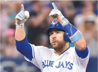  ??  ?? Russell Martin salue la foule après avoir frappé un circuit de deux points pour les Blue Jays de Toronto en sixième manche, dimanche. - La Presse canadienne: Frank Gunn