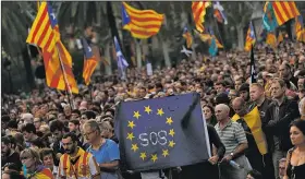  ?? AP/FRANCISCO SECO ?? Supporters of independen­ce for the Catalonia region hold up a message on a European Union flag Tuesday during a rally in Barcelona, Spain.