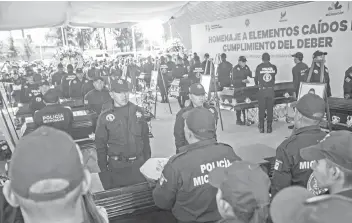  ?? — AFP photo ?? Relatives and members of the Police department of Michoacan pay tribute to the officers killed in an ambush on the eve, in Morelia, in the Mexican state of Michoacan.