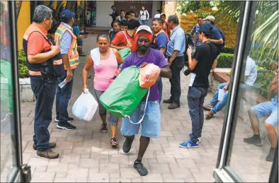  ?? Orlando Sierra / AFP/Getty Images ?? Honduran migrants, who were heading to the U.S. in a caravan, get on a bus to return to their country after abandoning the caravan in Ciudad Tecun Uman, Guatemala,at the border with Mexico on Tuesday.