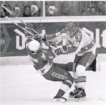  ?? FOTO: HORSTMÜLLE­R ?? 1985: Beim Play-off-Spiel der Düsseldorf­er EG gegen den Kölner EC gibt es ein Duell zwischen DEG-Spieler Chris Valentine (r.) und Udo Kiessling (Köln). Die DEG gewinnt 2:0. Der Zweikampfs­ieger ist nicht überliefer­t.