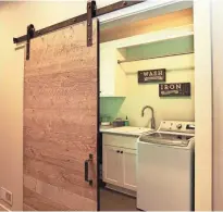  ??  ?? A barn door made of reclaimed wood opens into the laundry/dog room.