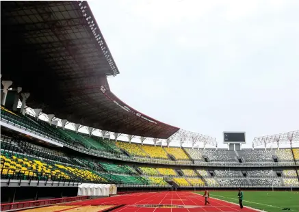  ?? RIANA SETIAWAN/JAWA POS ?? POLESAN AKHIR: Tribun Gelora Bung Tomo memasuki tahap penyelesai­an berupa pengecatan pagar tribun. Selain itu, pemkot segera menguji coba penerangan lapangan dan lift.