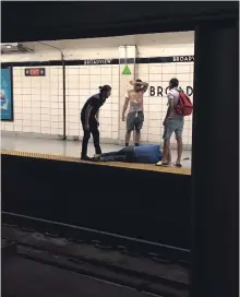  ?? JULIE CANIGLIA THE CANADIAN PRESS ?? Three men look on after rescuing a blind man who had fallen onto the subway tracks at Broadview Station in Toronto on Thursday.