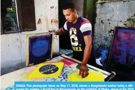  ??  ?? DHAKA: This photograph taken on May 17, 2018, shows a Bangladesh­i worker using a silkscreen for printing a Brazil flag in Narayangan­j, on the outskirts of Dhaka, ahead of the 2018 football World Cup. — AFP