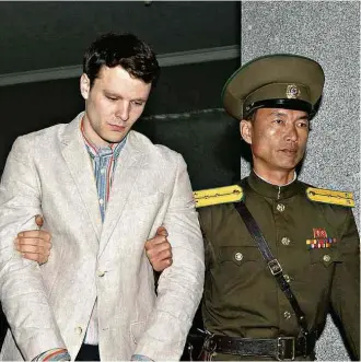  ?? Kyodo - 16.mar.2016/Reuters ?? Estudante Otto Warmbier é levado à Suprema Corte da Coreia do Norte, em março de 2016