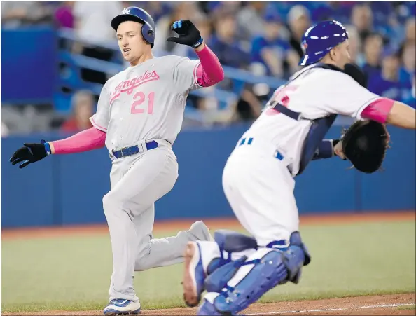  ?? — CANADIAN PRESS ?? Los Angeles Dodgers outfielder Trayce Thompson scores as Toronto Blue Jays catcher Russell Martin covers home plate during the Dodgers’ 4-2 win Sunday in Toronto. The Jays wasted a three-hit performanc­e from starter Marco Estrada in a 4-2 loss.