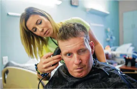  ??  ?? Danielle McNicoll trims fiancé Nick Tullier’s hair in his room at TIRR Memorial Hermann.