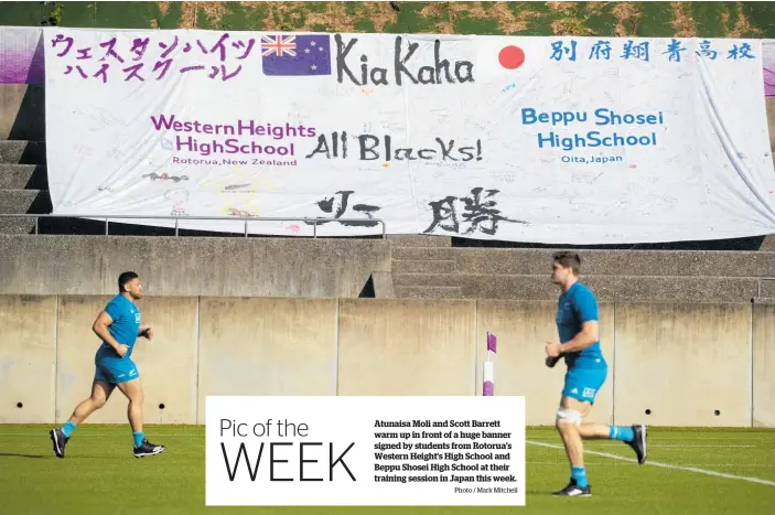  ?? Photo / Mark Mitchell ?? Atunaisa Moli and Scott Barrett warm up in front of a huge banner signed by students from Rotorua’s Western Height’s High School and Beppu Shosei High School at their training session in Japan this week.