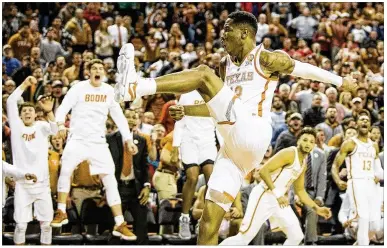  ?? NICK WAGNER / AMERICAN-STATESMAN ?? Kerwin Roach II is cheered by Texas teammates after a dunk in Wednesday night’s victory over Texas Tech. Cleared to play Wednesday morning after being out with a broken hand, Roach finished with 20 points.