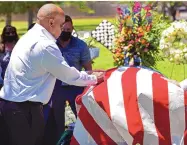  ?? JIM THOMPSON/JOURNAL ?? Willy T. Ribbs, who broke the color barrier driving at Indianapol­is in the early 1990s, gives a double fist bump to Bobby Unser’s casket at the grave site.