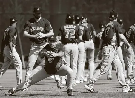  ?? Karen Warren / Staff photograph­er ?? Astros pitcher Justin Verlander, bottom, and other players would need another round of spring training to prepare for an early July start to the season, but first an agreement between the owners and players union on compensati­on must be worked out.