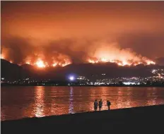  ?? AP ?? Onlookers are silhouette­d against the reflection of a wildfire burning in the Cleveland National Forest in Lake Elsinore, California, on Wednesday.