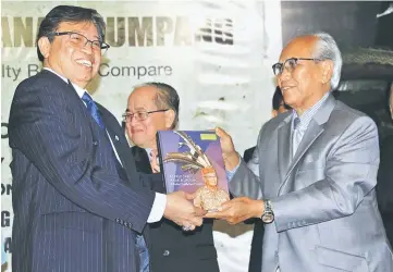  ??  ?? Jabu (right) presents a copy of the book to Abang Johari.