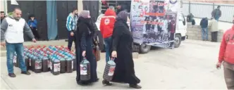  ??  ?? BEIRUT: Refugees collect diesel fuel to be distribute­d by KRCS to Syrians in Lebanon.