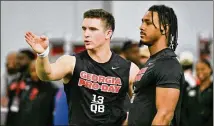  ?? HYOSUB SHIN/HYOSUB.SHIN@AJC.COM ?? Former UGA QB Stetson Bennett talks with running back Kenny Mcintosh (right) during the Bulldogs’ pro day in the Payne Indoor Athletic Facility on Wednesday.