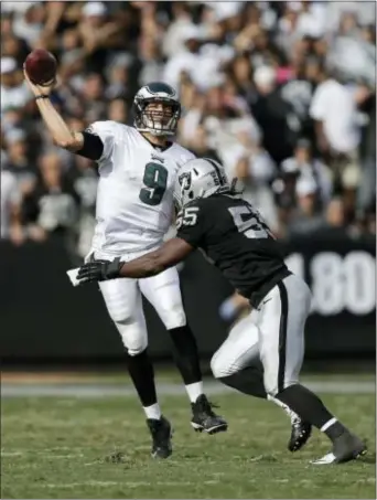  ?? MARCIO JOSE SANCHEZ — THE ASSOCIATED PRESS ?? Eagles quarterbac­k Nick Foles (9) passes as Raiders outside linebacker Sio Moore (55) applies pressure during the second quarter of a game on Nov. 3, 2013. Foles tied an NFL record with seven touchdown passes in that game.