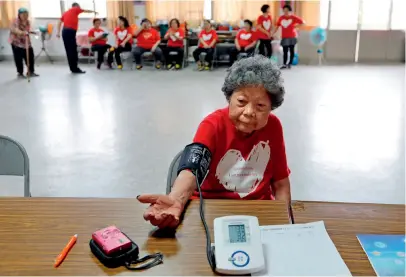  ??  ?? Le 24 avril 2018, Wang Chen Bijin, âgée de 91 ans, prend la tension artérielle.