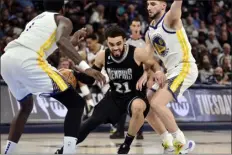  ?? BRANDON DILL — THE ASSOCIATED PRESS ?? Grizzlies guard Tyus Jones works between Warriors guard Ty Jerome, right, and forward Jamychal Green during the second half of Thursday’s game in Memphis, Tenn.