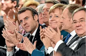  ?? AP ?? French President Emmanuel Macron, front left, German chancellor Angela Merkel, third right, and President of the European Council Donald Tusk, second right, applaud after the signing of a new Germany-France treaty at the historic Town Hall in Aachen, Germany.
