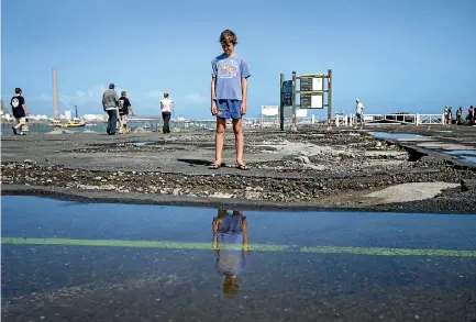  ?? PHOTO: ANDY JACKSON/STUFF ?? Jimmy Moffitt, 13, takes a look at the damage to the carpark at Port Taranaki.