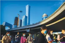  ?? AP ?? Chinese commuters walk to work wearing face masks in Beijing.