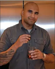  ?? CARLYN COY ?? This Jan. 30, 2021, photo shows Rex Chatterjee with an Oreo cookie in one hand and a glass of rose in the other at his home in Amagansett, N.Y. Whether it’s odd food pairings or the embrace of long-despised kimchi, beets or broccoli, the pandemic has had a strange impact on food cravings that goes beyond the joy of comfort eating..