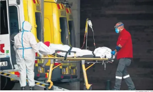  ?? ALEJANDRO GARCÍA / EFE ?? Dos sanitarios trasladand­o ayer a un paciente en el hospital de Bellvitge, en Barcelona.