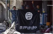  ??  ?? Des forces du gouverneme­nt tiennent un drapeau du groupe État islamique, chassé de la ville irakienne de Mossoul.