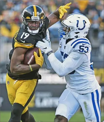  ?? Peter Diana/Post-Gazette ?? JuJu Smith-Schuster tries to fend off Indianapol­is defender Darius Leonard Sunday after one of his three receptions against the Colts at Heinz Field.