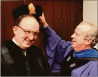  ?? Hearst Connecticu­t Media file photo ?? University of New Haven President Lawrence J. DeNardis helps then Major League Baseball Commission­er Fay Vincent with his scholars cap prior to the start of the 1992 commenceme­nt when Vincent received an honorary degree of Doctor of Laws and gave the commenceme­nt address.