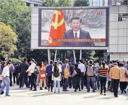  ??  ?? Transeúnte­s observan una pantalla de televisión con la imagen de Xi Jinping, en 2017.