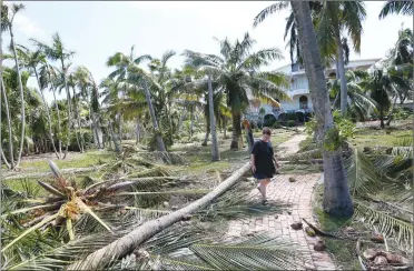  ?? Associated Press photo ?? Donnie Spielman walks through debris at her sister’s house where she and four other family members rode out Hurricane Irma along with several dogs, cats, birds and tortoises, Tuesday in Key Largo, Fla., in the Florida Keys.