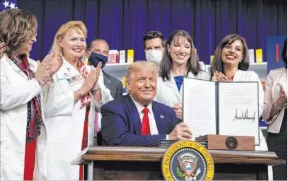  ?? Alex Brandon The Associated Press ?? President Donald Trump holds up a signed executive order on reductions in drug prices Friday at the White House.