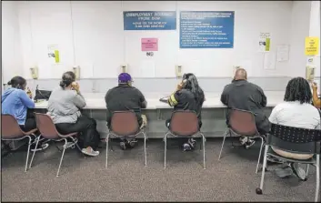  ?? The Associated Press file ?? Visitors use the phone bank at the California Employment Developmen­t Department office in Sacramento, Calif. Concerns of possible fraud are growing after reports of unsolicite­d debit cards arriving in people’s mailboxes and a suspicious­ly high number of claims involving independen­t contractor­s.