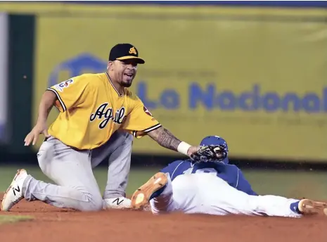  ?? GLAUCO MOQUETE / LISTÍN DIARIO ?? Pablo Reyes, del Licey, es puesto out por Robel García, de las Águilas en acción del partido de anoche en el torneo de béisbol otoño-invernal.