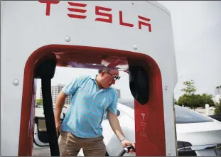  ?? STACEY WESCOTT/CHICAGO TRIBUNE FILE PHOTOGRAPH ?? Bill Borgeson charges his Tesla Model S in Rolling Meadows, Ill., on June 3.