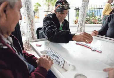  ?? PHOTOS BY SANDY HOOPER/USA TODAY ?? Locals carry on a Little Havana tradition in historic Domino Park.