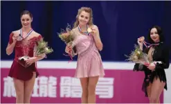  ?? — AFP ?? BEIJING: Elena Radionova (C) of Russia celebrates winning the gold medal of the ladies free skating on the podium as she stands next to Kaetlyn Osmond (L) of Canada who won silver and Elizaveta Tuktamyshe­va who took bronze at the Ice Dance short dance...