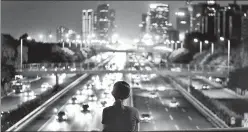  ?? AFP ?? ■
A woman looks out at a highway from a bridge in Beijing.