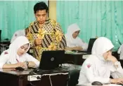  ?? ROBERTUS RISKY/JAWA POS ?? PENENTU KELULUSAN: Abdul Razzaq Thahir memantau siswa yang mengerjaka­n soal USP-BKS kemarin.