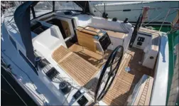  ??  ?? Le cockpit se veut moderne : du teck pour l’esthétique, deux barres à roue pour le confort en mer et une table repliable de bonne facture !