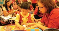  ??  ?? QUALITY TIME: Anak dan orang tua menikmati waktu kebersamaa­n dalam menghias angpao.