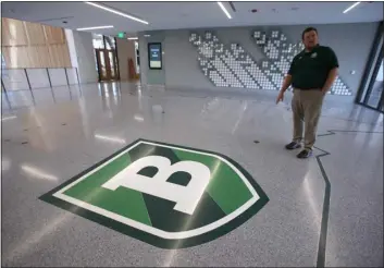  ?? JULIA MALAKIE — LOWELL SUN ?? Superinten­dent of Schools Tim Piwowar gives a tour of the new Billerica Memorial High School on Aug. 27, 2019. A map of Billerica that makes up the main lobby floor.